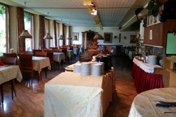 Restauracja z nakrytymi stołami i bufetowymi stacjami.