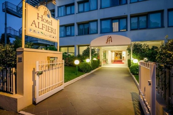 Wejście do hotelu Alfieri z wieczornym oświetleniem.