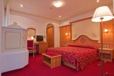 Pokój hotelowy z łóżkiem małżeńskim, czerwonym dywanem i klasycznym wystrojem wnętrza.