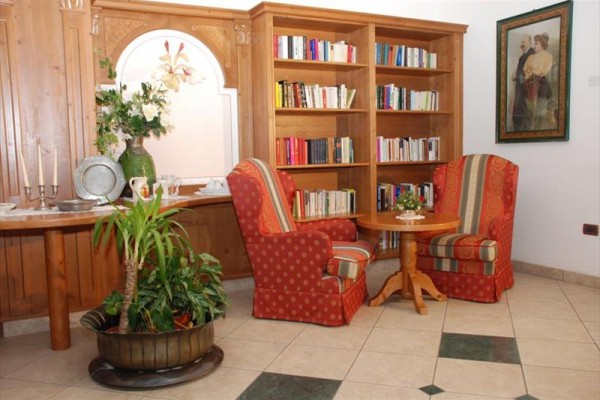 Biblioteka z fotelami i stolikiem w przytulnym salonie.