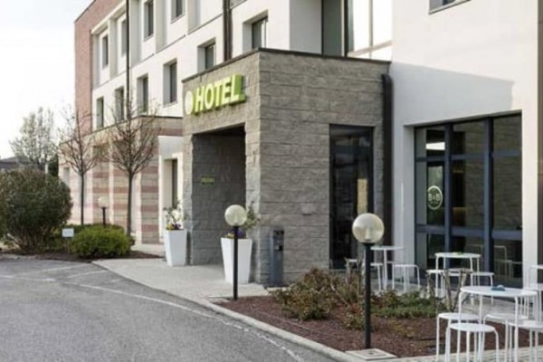Wejście do nowoczesnego hotelu z zewnętrznym miejscem do siedzenia.