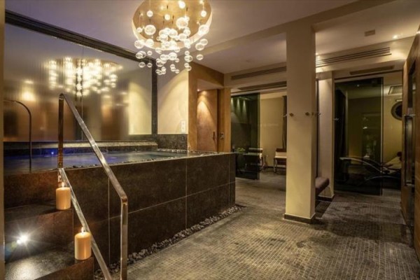 Luksusowe wnętrze spa z schodami do jacuzzi i nowoczesnym oświetleniem.
