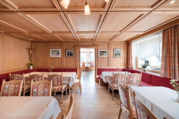 Restauracja z jasnym drewnianym wykończeniem i czerwonymi ławkami.