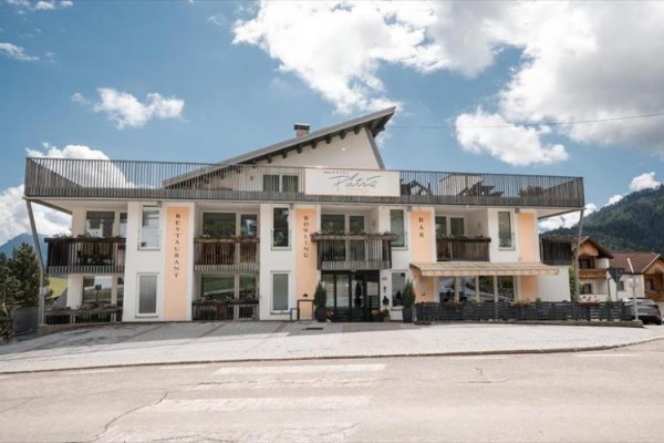 Budynek z restauracją, kręglami i barem w malowniczym alpejskim otoczeniu.
