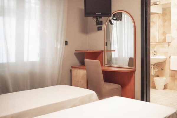 Pokój hotelowy z dwoma łóżkami i toaletką.