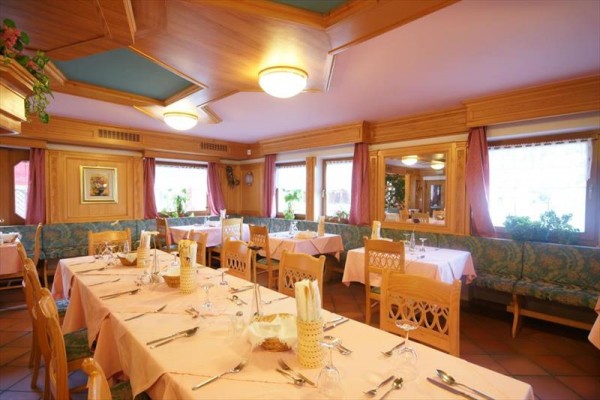 Stylowa restauracja z drewnianymi wykończeniami i nakrytymi stołami.