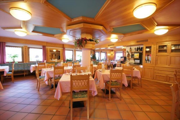 Elegancka restauracja z drewnianym wnętrzem i nakrytymi stołami.