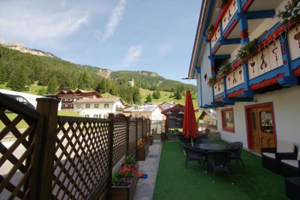 Taras hotelowy z kwiatami i widokiem na góry.