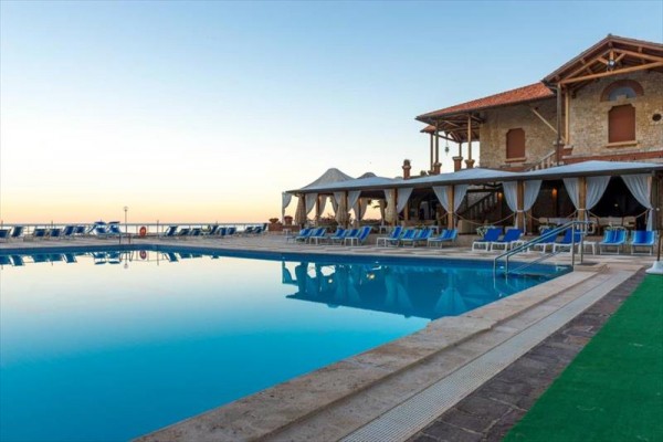 Luksusowy hotel przy odkrytym basenie o zmierzchu.