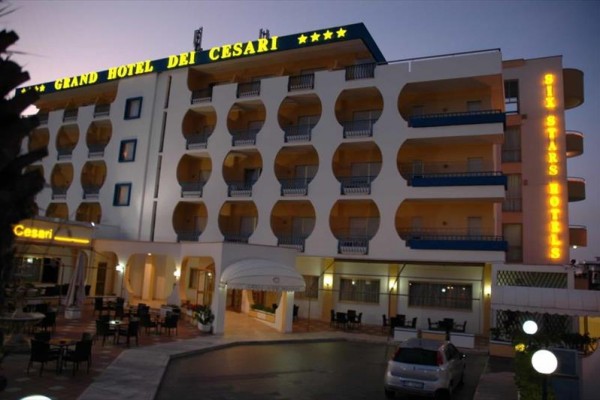 Wieczorny widok na oświetlony hotel o nazwie Grand Hotel dei Cesari.