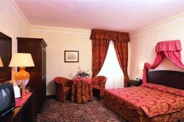 Luksusowy pokój hotelowy z dużym łóżkiem i eleganckimi meblami.