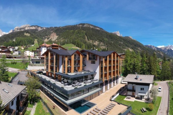 Hotel z basenem pośród górskiego krajobrazu.