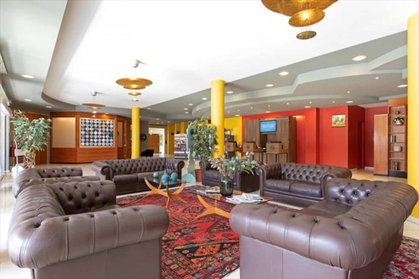 Luksusowe lobby hotelowe z kanapami Chesterfield i kolorowym dywanem.
