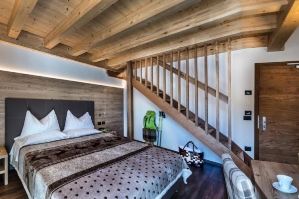 Nowoczesny pokój hotelowy z drewnianym sufitem i schodami.