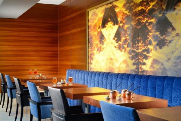 Nowoczesna restauracja z niebieskimi krzesłami i stolikami z napojami.