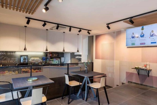 Nowoczesne wnętrze bistro z drewnianymi stołami i wiszącymi lampami.