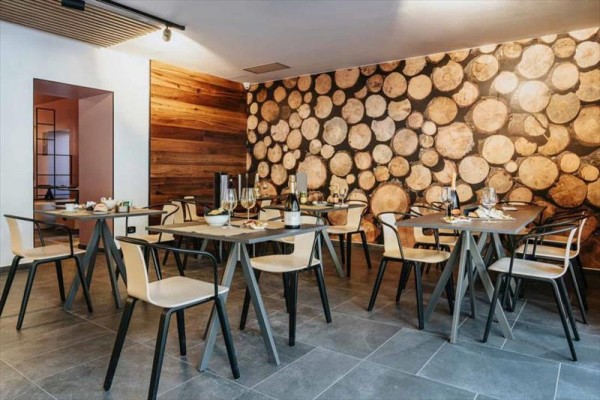 Nowoczesna restauracja z drewnianymi elementami dekoracyjnymi na ścianie.