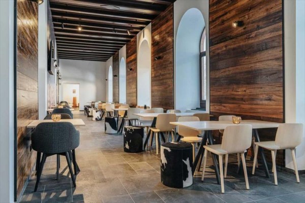 Nowoczesne wnętrze restauracji z drewnianymi ścianami i minimalistycznymi meblami.