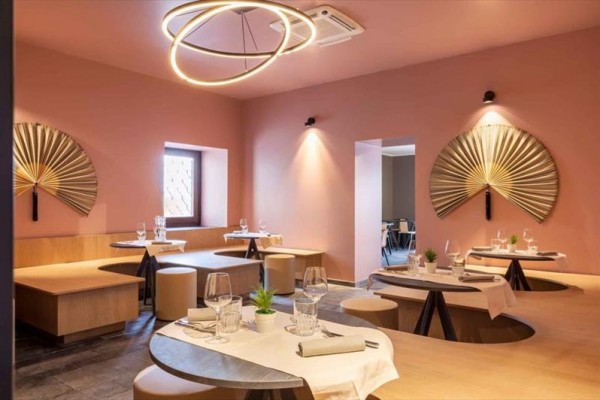 Nowoczesna restauracja z okrągłymi stołami i dekoracjami na ścianach.