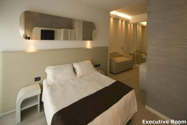 Elegancki pokój hotelowy z podwójnym łóżkiem i nowoczesnymi meblami.
