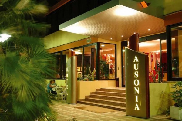 Wejście do hotelu z neonowym napisem 