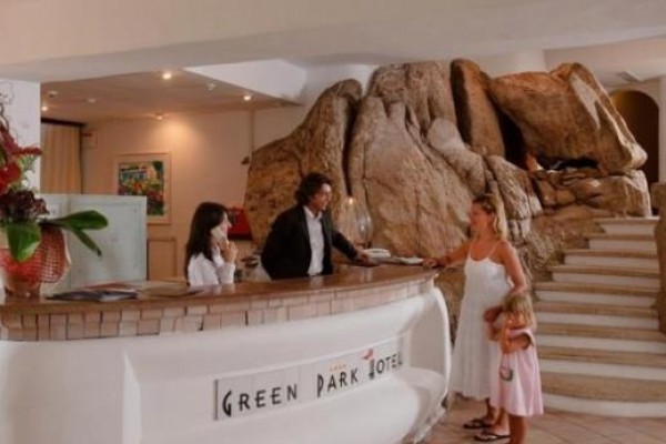 Recepcja hotelu z naturalną kamienną dekoracją i dwojgiem gości.
