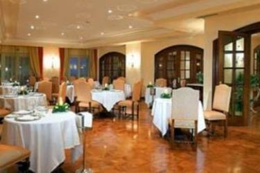 Elegancka restauracja z okrągłymi stołami i krzesłami pośrodku sali.