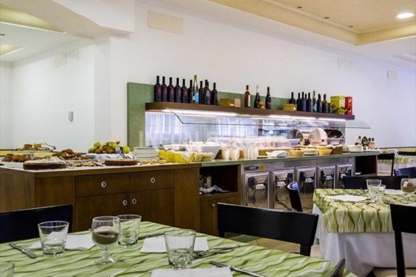Restauracja z zastawionym stołem i bufetem pełnym jedzenia i napojów.