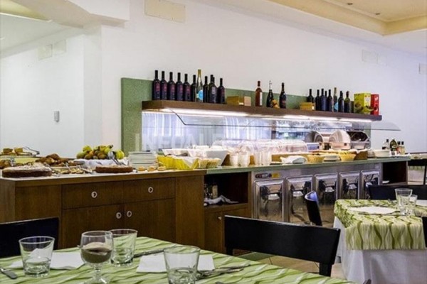 Bufet samoobsługowy z ofertą napojów i jedzenia w restauracji z nakrytymi stołami.