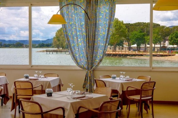 Restauracja z widokiem na jezioro i wybrzeże przez duże okna.