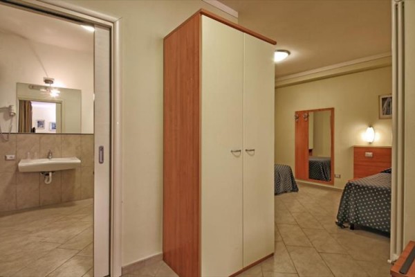 Pokój hotelowy z otwartą łazienką i szafą.