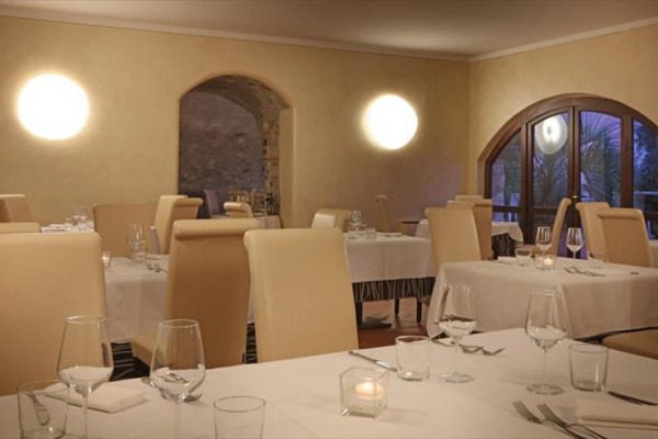 Restauracja z elegancko nakrytymi stołami i dużymi oknami.