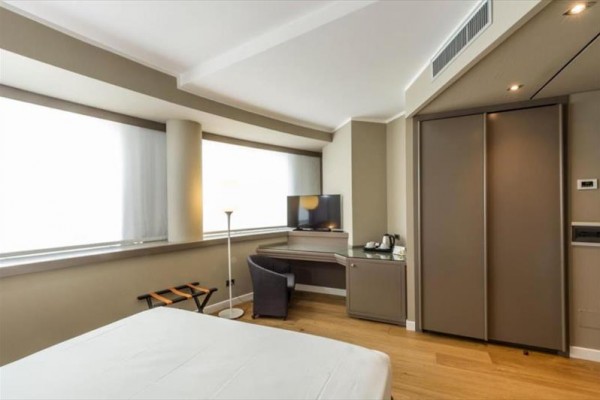Pokój hotelowy z łóżkiem, biurkiem i telewizorem.