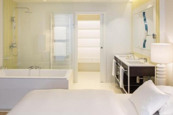 Nowoczesny pokój hotelowy z wanną, łóżkiem i łazienką.