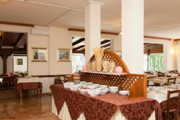 Restauracja z bufetowym stołem pełnym misek w jasnym wnętrzu.