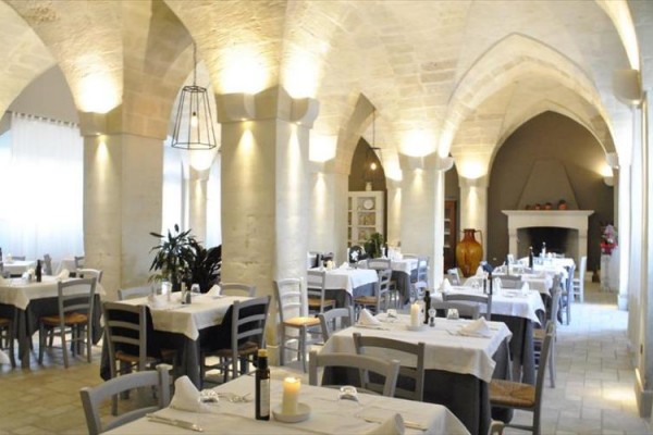 Średniowieczna restauracja z sklepieniami i nakrytymi stołami.