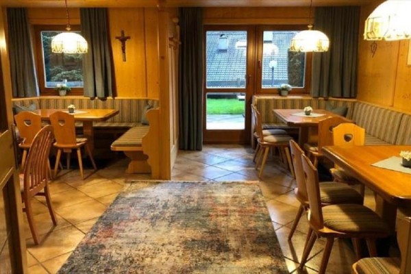 Restauracja z drewnianą boazerią, ławkami i stołami jadalnymi.