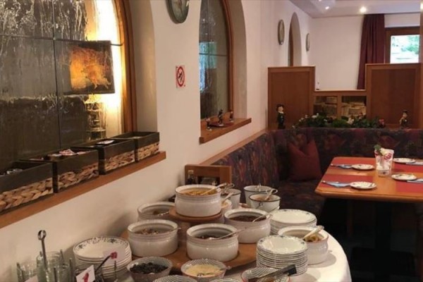 Stół jadalny w restauracji z różnorodnymi naczyniami i talerzami przygotowanymi do serwowania posiłków.