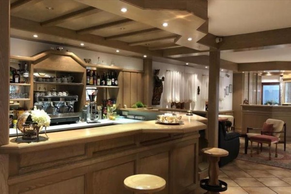 Stylowy drewniany bar z napojami i ekspresem do kawy w eleganckiej restauracji.