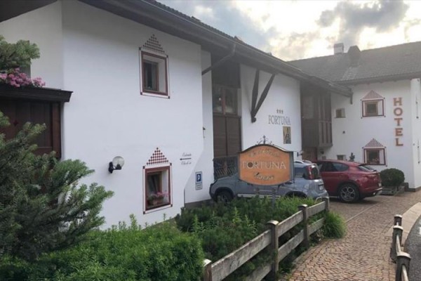 Budynek hotelu z parkingiem i napisem 