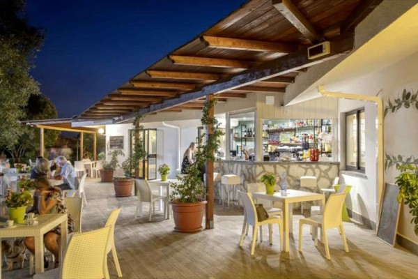 Restauracja z zewnętrznym miejscem do siedzenia wieczorem po zmroku.