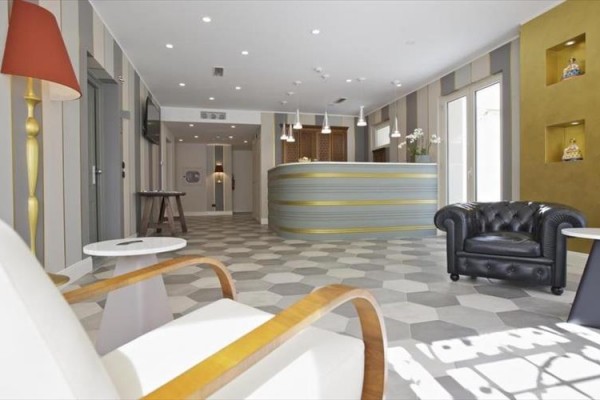 Nowoczesna recepcja hotelowa z wygodnymi fotelami i designerskim oświetleniem.
