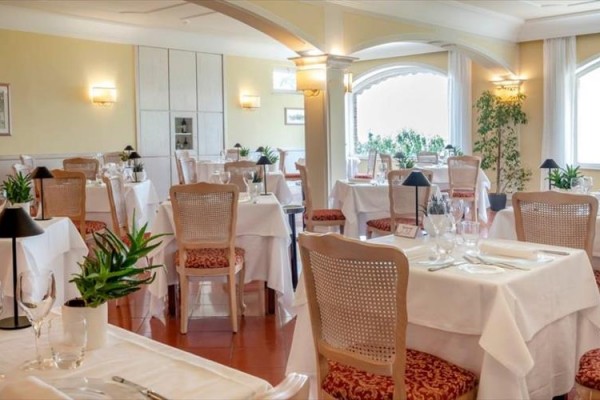 Elegancka restauracja z nakrytymi stolikami i kwiatową dekoracją.