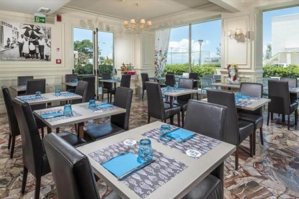 Elegancka restauracja z nakrytymi stołami i skórzanymi krzesłami.