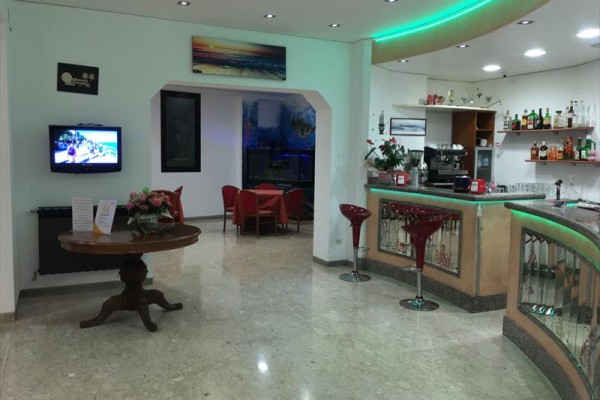 Nowoczesny bar hotelowy z podświetlonym blatem, stolikami i krzesłami.