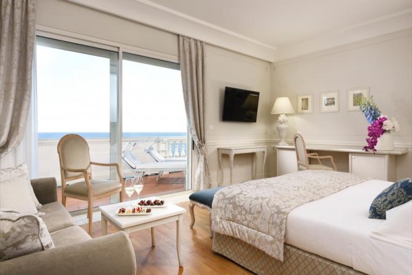 Luksusowy pokój hotelowy z tarasem i widokiem na morze.
