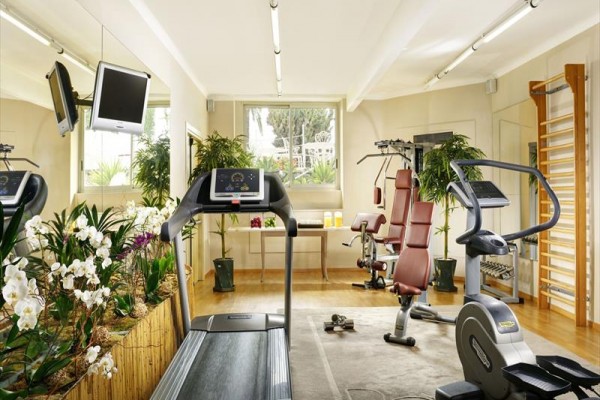Nowoczesne centrum fitness z maszynami do ćwiczeń i lustrem.