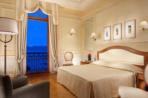 Elegancki pokój hotelowy z widokiem na morze z balkonu.