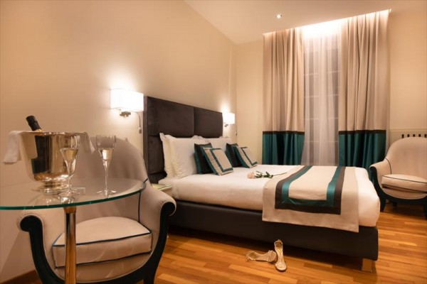 Luksusowy pokój hotelowy z łóżkiem małżeńskim i eleganckimi meblami.