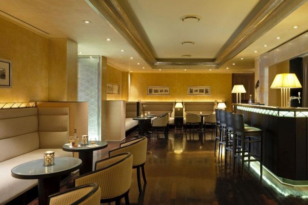 Elegancki hotelowy bar z wygodnymi fotelami i podświetlonym blatem.